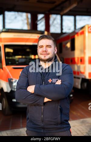 Bad Krozingen, Deutschland. April 2020. Simon Manninger (26), Notarzt des DRK, steht zu Beginn seiner Nachtschicht vor der Fahrzeughalle der Rettungsstation. Er ist in der Notrettung tätig und wird sowohl als Fahrer des Rettungswagens (NEF) als auch im Rettungswagen (RTW) eingesetzt. (Zu dpa: 'Simon Manninger kann bei der Rettung nicht Abstand halten') Quelle: Philipp von Ditfurth/dpa/Alamy Live News Stockfoto