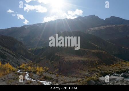 Malerische Aussicht auf die direkten goldenen Sonnenstrahlen am Abend, die auf die friedlichen Berge fallen. Regenbogeneffekt. Wunderschöne Naturlandschaft. Weitwinkelansicht. Stockfoto