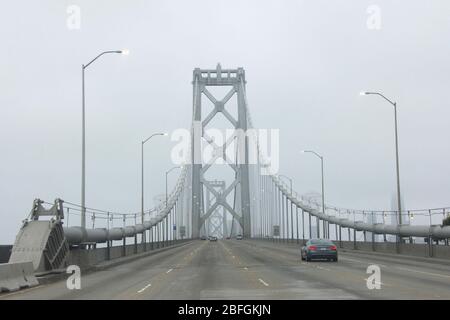 Fahren Sie mit dem POV über das Oberdeck der Bay Bridge nach San Francisco an einem sehr nebligen Tag, typisch für die Bay Area. Stockfoto