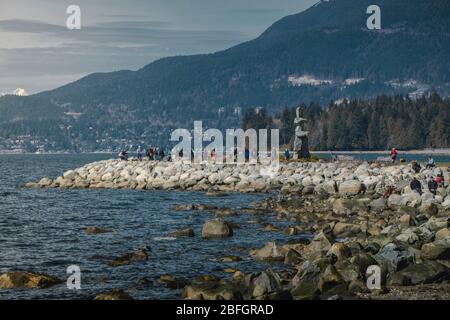 Beliebtes Wellenbrecher mit riesigen Inkukshuk in der Mitte und Bergen dahinter. Stockfoto