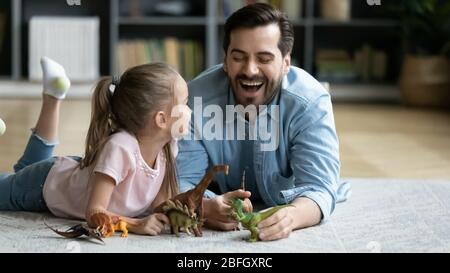 Vater Spaß mit kleinen Tochter spielen mit Dinosaurier-Spielzeug Stockfoto