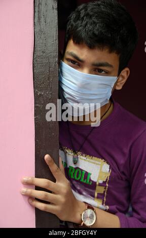 Besorgtes und besorgtes Kind mit schützender Gesichtsmaske, das die verlassenen Straßen in Indien beobachtet - wegen Covit19 Coronavirus-Pandemie. Sein Land (I Stockfoto