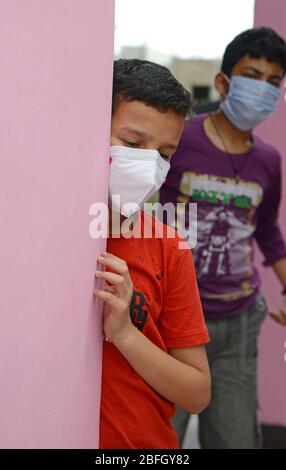 Besorgtes und besorgtes Kind mit schützender Gesichtsmaske, das die verlassenen Straßen in Indien beobachtet - wegen Covit19 Coronavirus-Pandemie. Sein Land (I Stockfoto