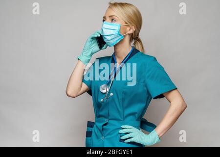Arzt Krankenschwester Frau mit Schutzmaske und Latexhandschuhe - Gespräch am Telefon Stockfoto