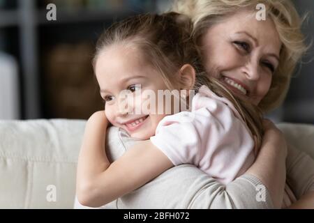 Im Alter Großmutter streichelt geliebten Enkelin umarmt ihre Nahaufnahme Stockfoto