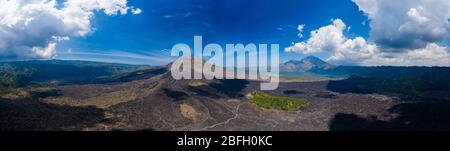 Luftaufnahme von erstarrten schwarzen vulkanischen Lavaströmen um die Hänge eines aktiven Vulkans. (Mount Batur) Stockfoto