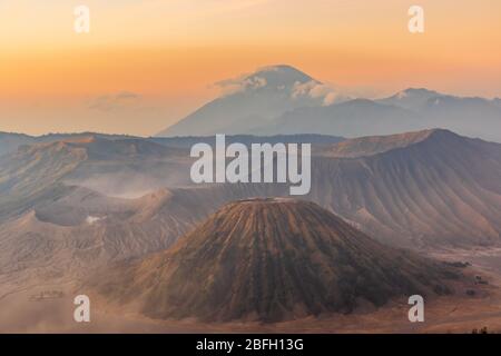 Sonnenaufgang über dem Mount Bromo und Semeru Vulkan Komplex an einem roten, staubigen Morgen gibt der Landschaft ein rotes, marsianisches Aussehen Stockfoto