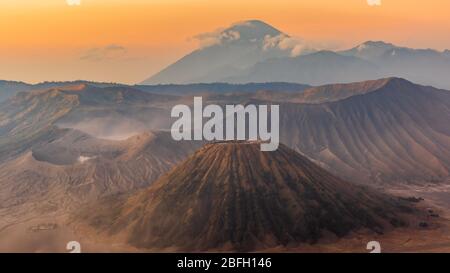 Sonnenaufgang über dem Mount Bromo und Semeru Vulkan Komplex an einem roten, staubigen Morgen gibt der Landschaft ein rotes, marsianisches Aussehen Stockfoto