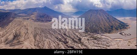 Panorama-Luftaufnahme des aktiven Vulkans Mount Bromo und des Mount Batok Cider Kegels neben dem "Meer des Sandes" in Java, Indonesien Stockfoto