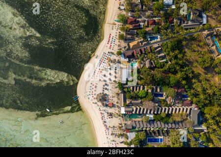 Von oben aus hat man einen Blick auf die Sonnenschirme und Sonnenschirme an einem tropischen Strand Stockfoto