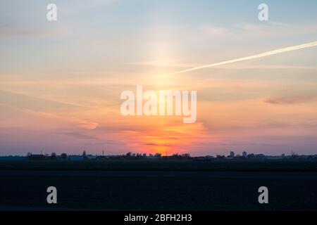 Sonnensäule kurz nach Sonnenuntergang. Atmosphärisches optisches Phänomen. Stockfoto