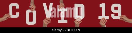 Hände von Menschen halten Covid 19 Wort Stockfoto