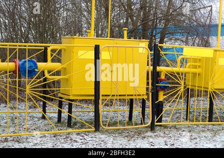 Gelbe Gasverteilerstation. Die Gasleitung ist gelb mit zusätzlicher Ausrüstung, Rohren und einem Ventil. Stockfoto