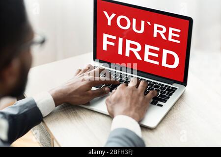 Besorgt african american Mann Blick auf Laptop mit Inschrift Sie gefeuert werden Stockfoto