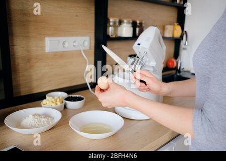 Nahaufnahme Frau Hände brechen Hühnereier in einem Teller in der Küche. Teig kochen. Stockfoto