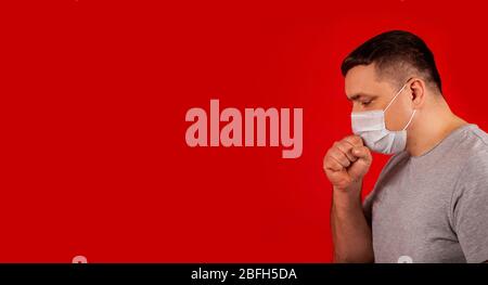 Porträt eines jungen kranken Mannes in einer medizinischen Schutzmaske hustet und sich krank fühlt. Kranker Mann krank mit Brustschmerzen. Symptome des pandemischen Coronavirus COVID-19, Grippe, Erkältungen oder Lungenentzündung Stockfoto