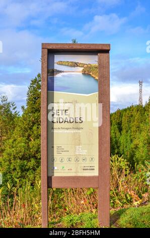 Sete Cidades, Azoren, Portugal - 12. Januar 2020: Informationsschild für Touristen in Sete Cidades. Hölzerne touristische Zeichen in portugiesischem Landschaftsschutzgebiet. Grüner Wald im Hintergrund. Vertikales Foto. Stockfoto