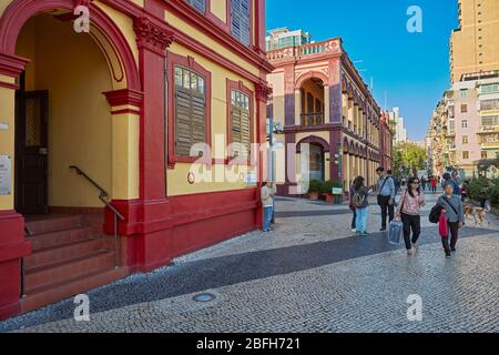 Menschen, die am farbenfrohen Gebäude der Macao Central Library in Macau, China, vorbeilaufen. Stockfoto