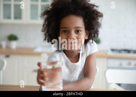 Porträt von niedlichen biracial kleines Mädchen trinken Mineralwasser Stockfoto