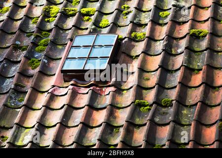 Dachfenster auf alten Keramikfliesen Hausdach. Stockfoto