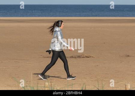 Southport, Merseyside. Wetter in Großbritannien. April 2020. Ein weiterer heller sonniger Frühlingstag im April im Badeort, während die Einheimischen leichte Übungen am weiten Küstenstrand am nordwestlichen Ainsdale Beach machen. Minister Michael Gove sagte, es sei zu früh, die Beschränkungen der Personenbewegung aufzuheben, und die Regeln der sozialen Distanzierung werden noch einige Zeit gelten. Quelle: MediaWorldImages/AlamyLiveNews Stockfoto