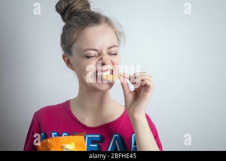 Lächelnd junge kaukasische Frau Mädchen essen beißende Kartoffelchips Chips Chips Stockfoto