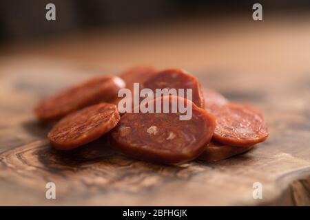 Scheiben Chorizo auf olivem Holzbrett Stockfoto