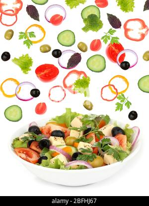 Frisches gemischtes Gemüse fällt in Schale Salat auf weiß isoliert Stockfoto
