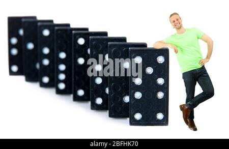 Junger Mann mit Dominosteine isoliert auf weiß Stockfoto