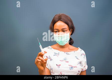 Coronavirus Epidemie aus china. Selektive Fokus. Frau Arzt verwenden Spritze. Krankenschwester machen Injektion in Atemschutzmaske. Gesundheitsarbeiter wählt Impfstoff in sy Stockfoto