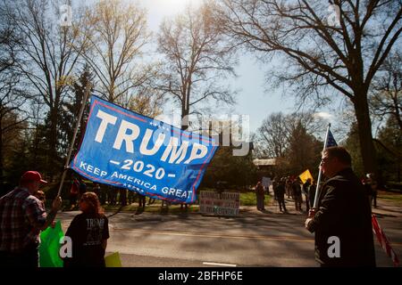 Ein Protestler kämpft für Trump und protestiert gleichzeitig gegen den Gouverneur von Indiana.Demonstranten versammeln sich vor dem Anwesen des Gouverneurs von Indiana, Eric Holcomb, im Block 4700 der N. Meridian Street, um gegen das zu protestieren, was sie als "Regierungsüberreichungen" als Unternehmen beschreiben. Und Institutionen, weiterhin geschlossen werden während der Aufenthalt-at-Home-Ordnung, um die Ausbreitung von COVID-19 / Coronavirus im Staat zu bekämpfen. Der Protest wurde organisiert, nachdem die Demonstranten in Michigan Anfang der Woche protestierten. Ähnliche Proteste haben in den Vereinigten Staaten stattgefunden, wie es Facebook-Seiten und Webseiten getan haben Stockfoto