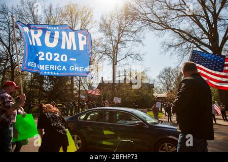 Ein Protestler kämpft für Trump und protestiert gleichzeitig gegen den Gouverneur von Indiana.Demonstranten versammeln sich vor dem Anwesen des Gouverneurs von Indiana, Eric Holcomb, im Block 4700 der N. Meridian Street, um gegen das zu protestieren, was sie als "Regierungsüberreichungen" als Unternehmen beschreiben. Und Institutionen, weiterhin geschlossen werden während der Aufenthalt-at-Home-Ordnung, um die Ausbreitung von COVID-19 / Coronavirus im Staat zu bekämpfen. Der Protest wurde organisiert, nachdem die Demonstranten in Michigan Anfang der Woche protestierten. Ähnliche Proteste haben in den Vereinigten Staaten stattgefunden, wie es Facebook-Seiten und Webseiten getan haben Stockfoto