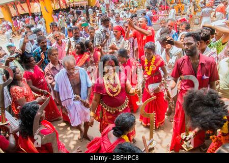 Anhänger im roten Kleid und Sickleshaped Schwerter am Sree Kurumba Sree Kurumba Bhagwati Tempel Kodungallur, während Bharani Festival, Thrissur, Kerala, Indien Stockfoto