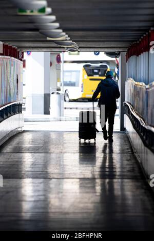 Berlin, Deutschland. April 2020. Ein Passagier mit Gepäck geht zum Eingang des Flughafens Tegel. Quelle: Fabian Sommer/dpa/Alamy Live News Stockfoto