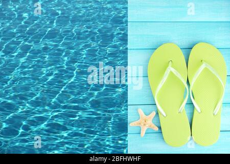 Bunte Flip Flops auf Holzplattform neben dem Meer Stockfoto