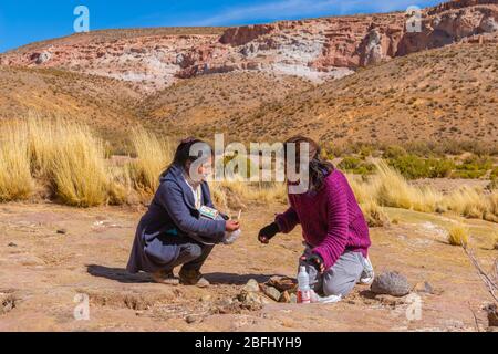 Pachamama-Feier mit Alkoholzigaretten und Coca-Blättern vor dem Picknick im Freien, Susques, Department Jujuy, Argentinien, Lateinamerika Stockfoto