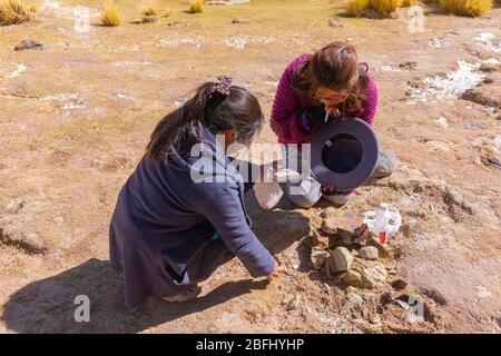 Pachamama-Feier mit Alkoholzigaretten und Coca-Blättern vor dem Picknick im Freien, Susques, Department Jujuy, Argentinien, Lateinamerika Stockfoto