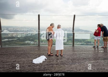Singapur / Singapur - 15. Februar 2019: Touristenpaar im Badeanzug fotografieren im Sands SkyPark Observation Deck während regnerischem Coody Day Stockfoto