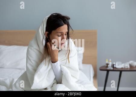 Kranke junge Frau eingewickelt leiden an kalten Symptomen zu Hause Stockfoto