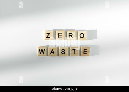 Null Abfall Text geschrieben von hölzernen Buchstaben auf weißem Hintergrund. Flach liegend, Draufsicht. Stockfoto