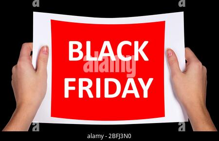 Hände, die Black Friday Werbung isoliert auf schwarz halten Stockfoto