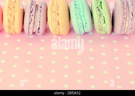 Leckere Makronen auf rosa Tupfen Hintergrund Stockfoto