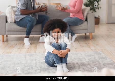 Unschuldiges kleines afroamerikanisches Mädchen, das unter Familienkonflikten leidet Stockfoto