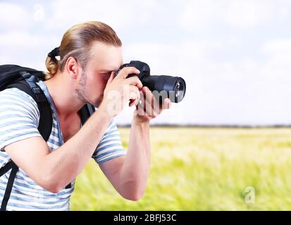 Junger Fotograf, der im Freien fotografiert Stockfoto