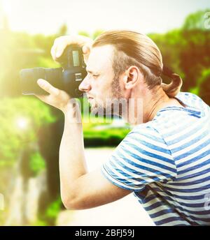 Junger Fotograf, der im Freien fotografiert Stockfoto