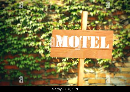 Schild mit Text Motel auf Backstein-Wand Hintergrund Stockfoto