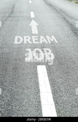 Text Traumjob mit Pfeilmarkierung auf Straßenbelag Stockfoto