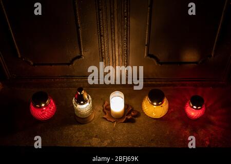 Grabkerzen Lichter an den Türen zu einem alten Grab in einem Friedhof in der Nacht, Vintage stilisierte Retro-Look Stockfoto