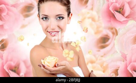 Schöne junge Frau mit Creme Rose auf rosa Blume Hintergrund Stockfoto