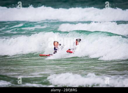 Cornish Surfers genießen das weiße Wasser Stockfoto